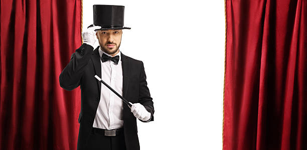 istock Magician performing on a stage with red curtain 2206699338