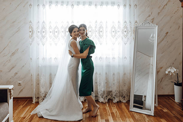 istock A bride and her mother are standing in front of a mirror 2206699783