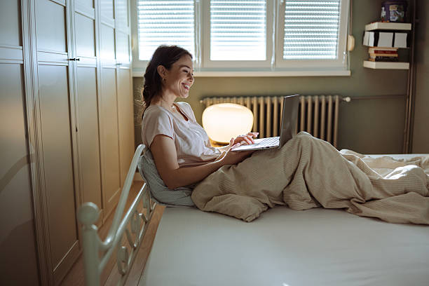 istock Smiling woman journaling on bed during relaxing morning sunlight 2206700462