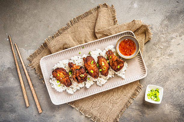 istock Deep fried chicken wings with sauce on rice on rustic gray concrete background 2206701640