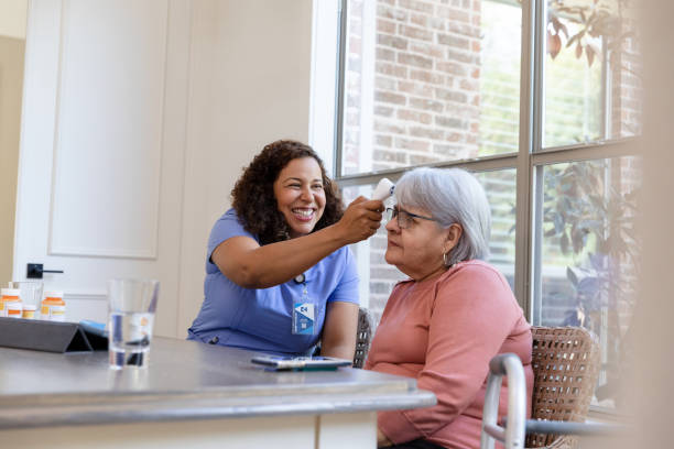 istock Nurse using contactless thermometer on senior patient at home 2206702519