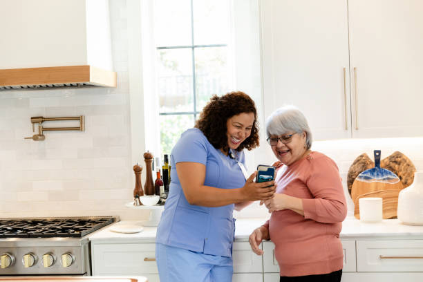 istock Senior Woman and Caregiver Using Smart Phone Together 2206702602