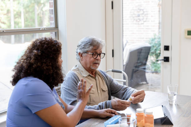 istock Senior Man and Caregiver Discussing Medication, Using Tablet 2206702606