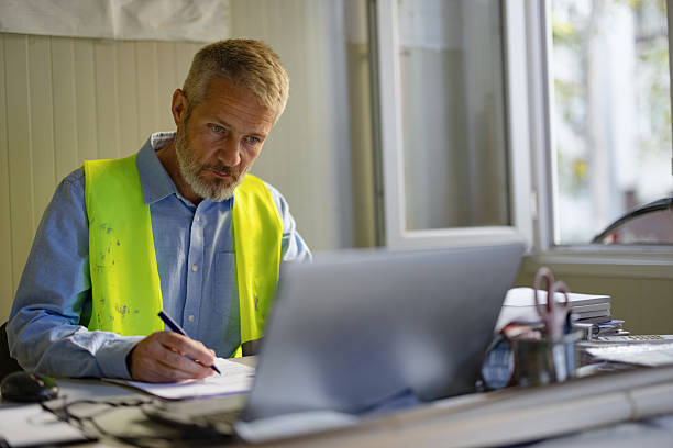 istock Male Office Worker Reviewing Documents in Bright Office Environment 2206703131