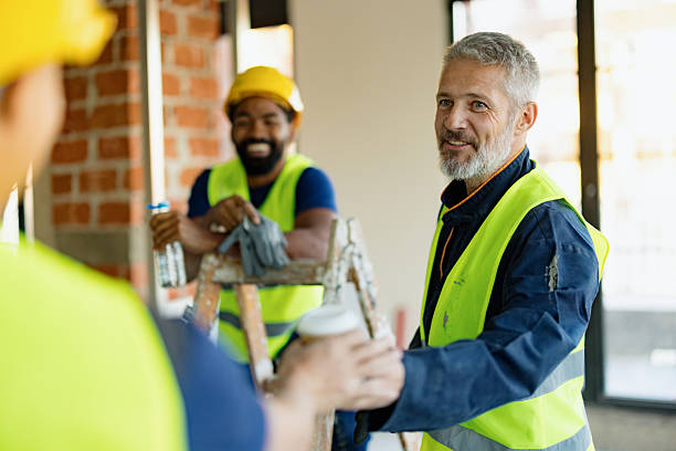istock Construction Workers Collaborating on a Jobsite Wearing Yellow Safety Vests and Helmets 2206703165