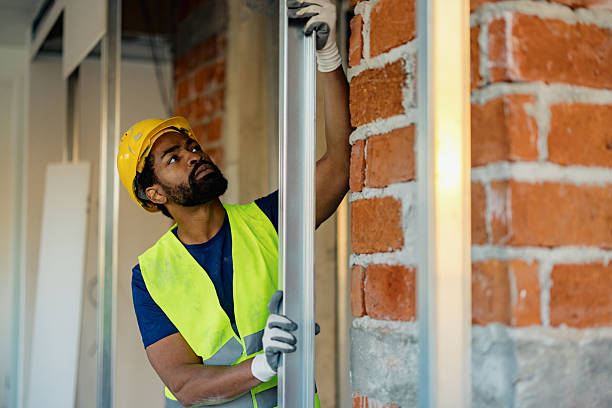 istock Construction Worker Inspecting Metal Frame in Renovation Site with Brick Walls 2206703175