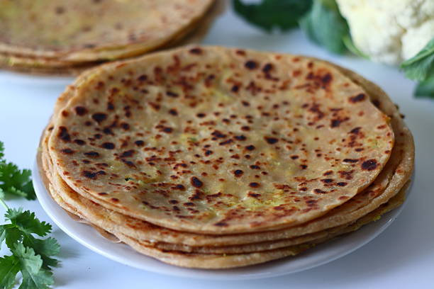 istock Delicious gobi paratha served alongside a fresh cauliflower bulb with leaves. 2206703925