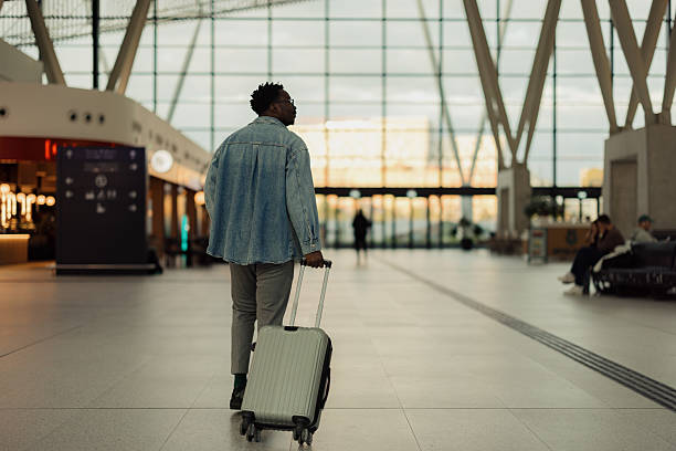 istock Traveler Walking Through Modern Airport Terminal with Suitcase 2206705311