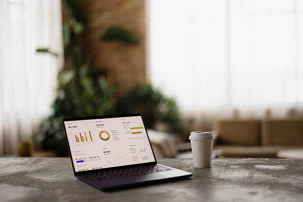 istock Laptop With Business Analytics and Coffee Cup in Modern Bright Office Space 2206706354