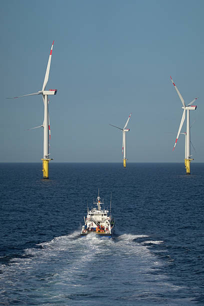 istock Vessel Navigating Towards Giant Offshore Wind Turbine, Leaving Wake. 2206707199
