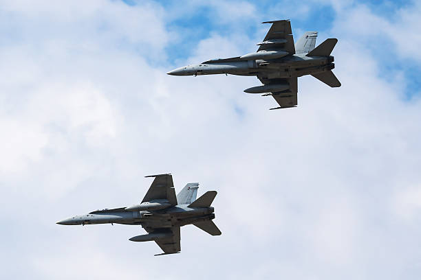 istock Two modern fighter jets flying in close formation against a bright, partly cloudy sky. 2206708021