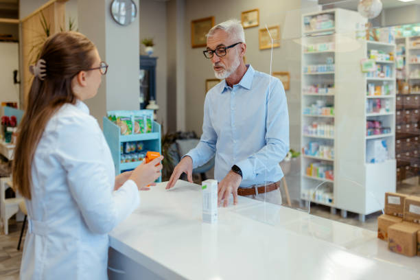 istock Elderly Customer Consults with Pharmacist While Choosing Medication 2206709361