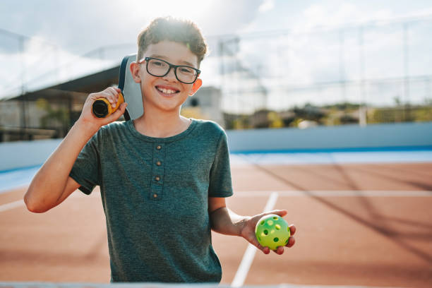 Boy on court with Pickleball equipment