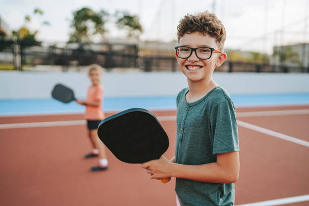 istock brother and sister playing pickleball together 2206712196