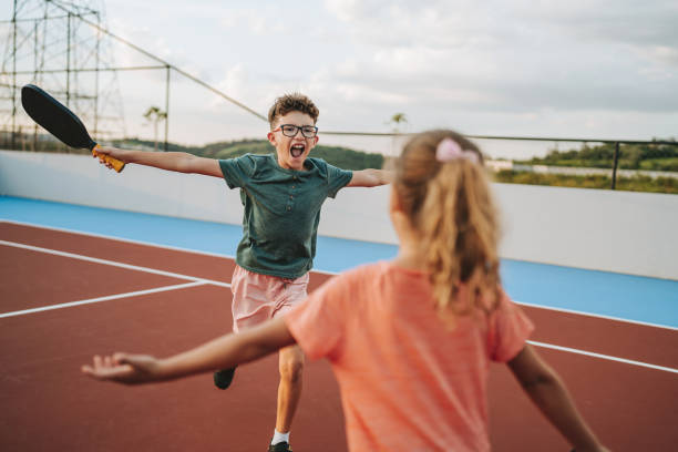 istock brother and sister playing pickleball together 2206712219