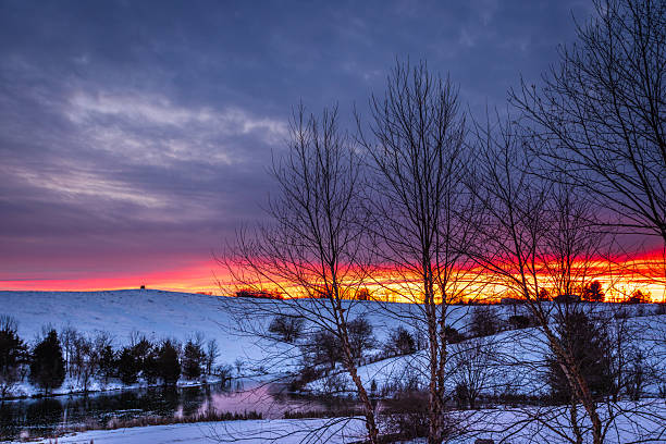 snowy New England countryside, dirt road, farm, and farm buildings in the winter