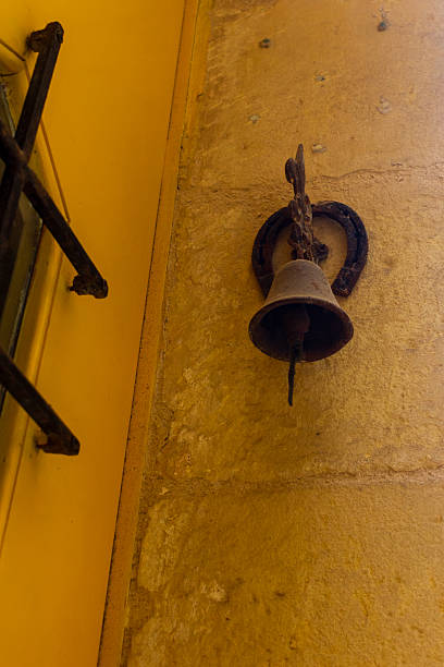 istock Vintage Metal Bell Mounted on Rustic Yellow Stone Wall 2206715085