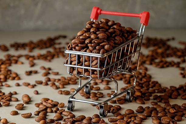 istock Coffee beans fill a tiny shopping cart on an artistic background 2206717648