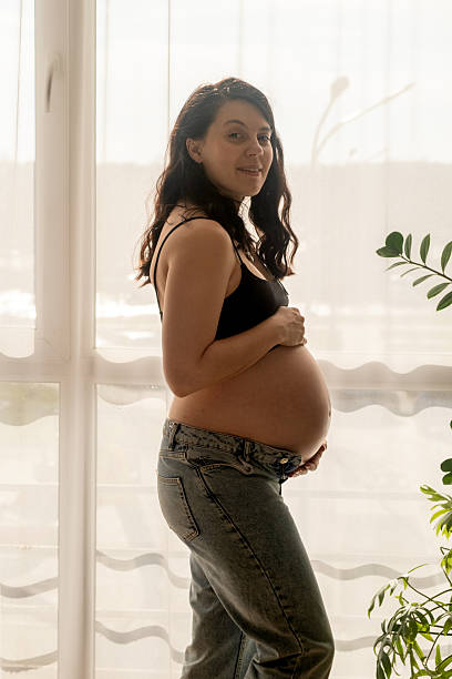 istock Pregnant Woman by Window in Natural Light 2206719167