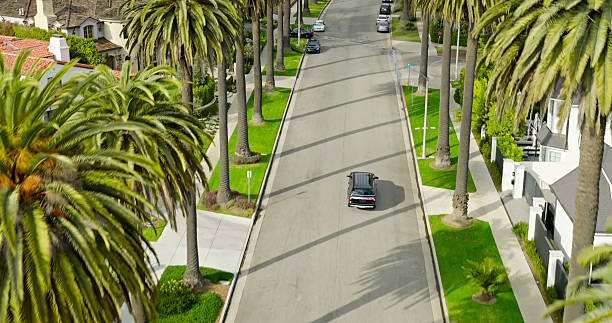Daytime aerial view of a black SUV driving through a residential area. Shot in Century City, California.