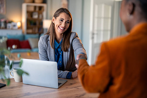 istock Smiling Professional Woman Shaking Hands in Home Office 2206722304