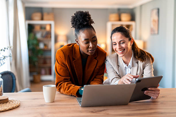 istock Smiling Professional Women Collaborating On Digital Project At Home Office 2206723092