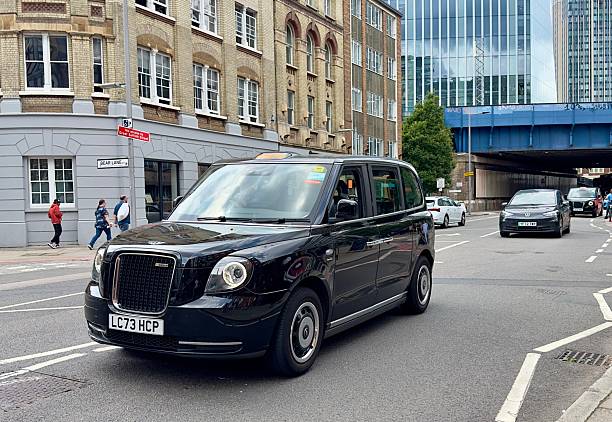 London, UK - July 24, 2024: A black London taxi being driven along a road in Southwark, London, England.