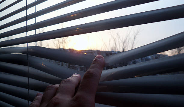istock Staying at home, quarantine, looking at a sunset through the blinds background 2206724606