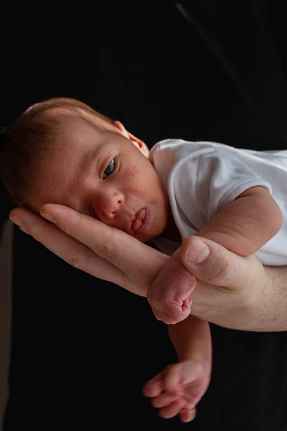 istock Newborn Baby Cradled in Hand 2206724663