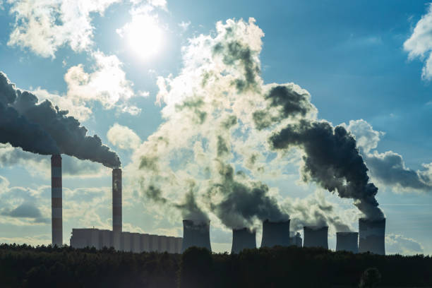 istock Industrial Factory Emitting Smoke Into Blue Sky, Highlighting Pollution and Climate Issues 2206724739