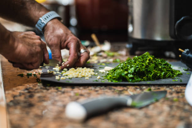 istock Chef chopping garlic and parsley on cutting board 2206728074