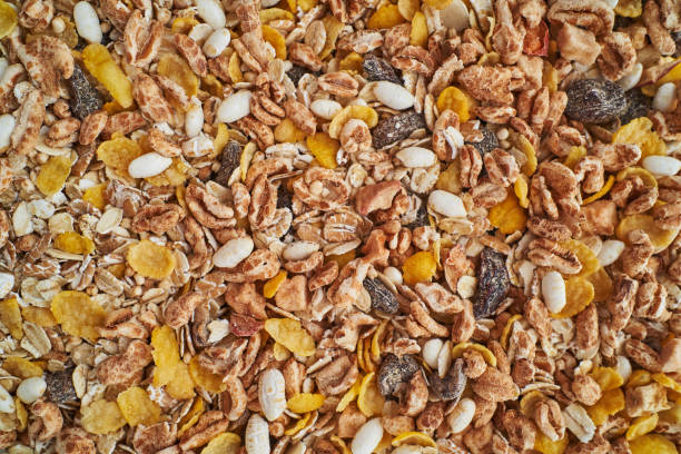 Close-up view of a diverse mix of muesli ingredients, including rolled oats, puffed rice, corn flakes, and dried fruits, creating a visually appealing and nutritious breakfast option