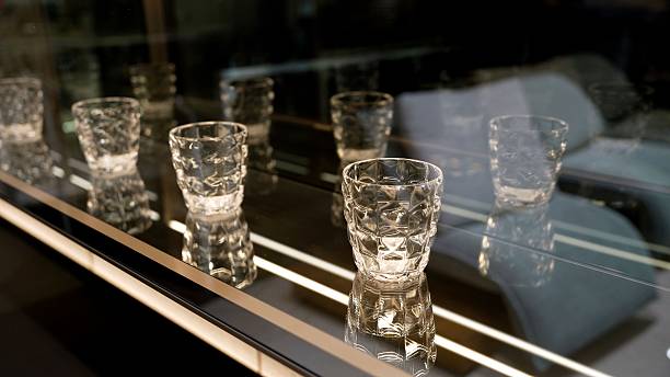 istock A set of empty empty glasses displayed in rows. There are beautiful crystal glasses for vodka on display. Lots of elegant empty glasses. 2206732820