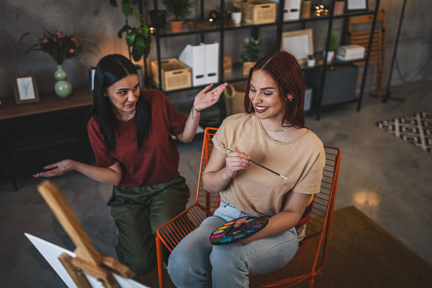 istock two young women paint at home mentor artist help to create art 2206735986