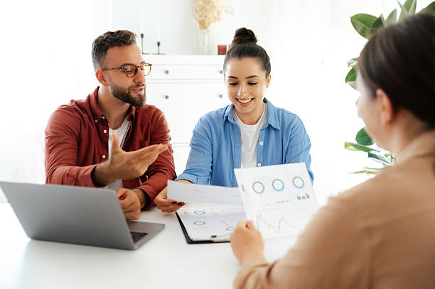 istock Teamwork concept in the office. A man and a woman are analyzing financial graphs together with a third colleague, reviewing data on documents and laptop, discussing results 2206739952