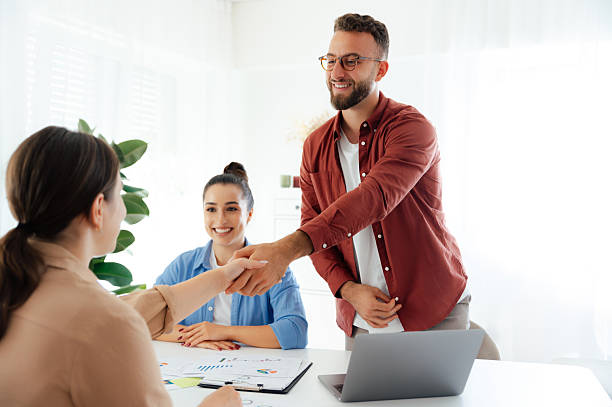 istock Teamwork. Successful agreement. The colleagues are shaking hands while smiling at each other. Group of business partners working together in the office on a project, make a deal, planning cooperation 2206739968