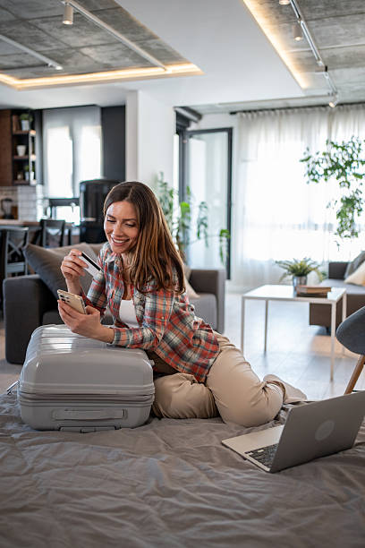 istock Woman booking a trip online using a credit card and smartphone 2206741349
