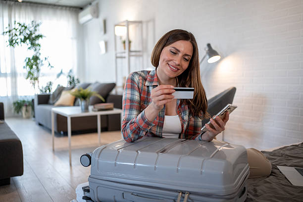 istock Woman booking travel accomodations online using smartphone and credit card 2206741380