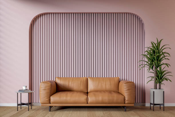 istock A modern, minimalist living room with a warm brown leather sofa set against a light (pale) pink wooden slat accent wall with copy space, surrounded by an arched muted light (pale) pink background and decoration 2206744564