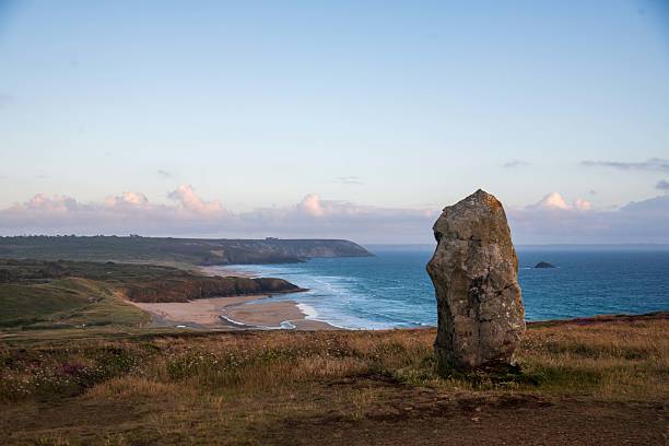 Sunset light over the La Palud beach in Crozon with menhir in the forefront