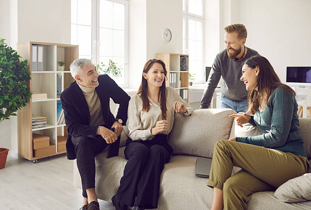 istock Smiling businesspeople laugh brainstorming ideas at workplace 2206747939