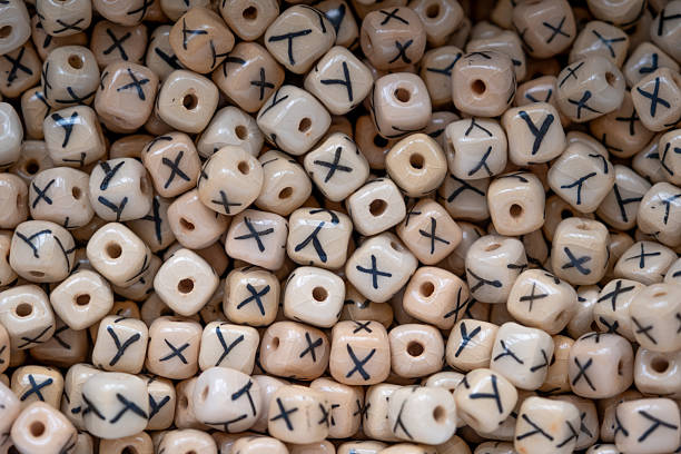 A tightly framed close-up of hand-carved ceramic beads featuring black tribal-style markings. The neutral earthy tones and geometric repetition make this a visually engaging and textured shot, ideal for backgrounds, cultural themes, crafts, or interior decor. No people are visible in the image.