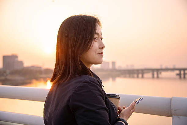 istock asian female using smart phone in city during sunset 2206748479