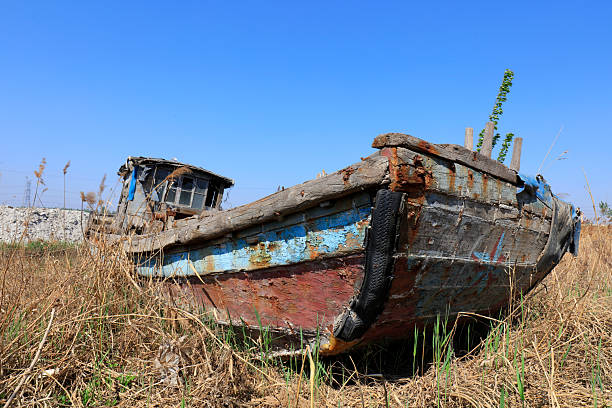 The broken wooden boat is on land