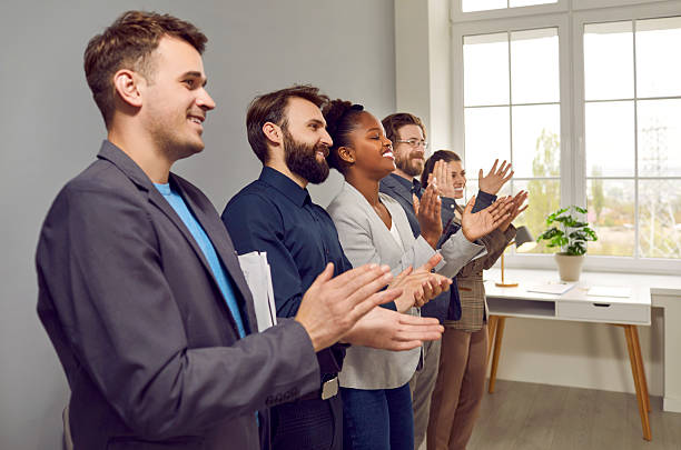 istock Multinational people working in same company applaud stand in office along wall 2206751914
