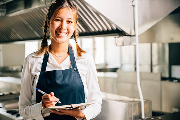 istock Professional chef's portrait in commercial kitchen. Holding note book pen for teaching. Expertise in education explaining skills. Working confidently presenting ideas to colleagues. Foor education 2206754028