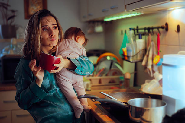 Mother Drinking Coffee and Cooking while Carrying Baby