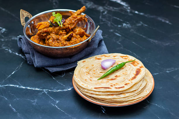 istock Crispy, flaky laccha paratha paired with rich, spicy chicken bhuna masala, bursting with aromatic spices, tender chicken, and buttery layers—perfect for a hearty, flavorful meal. 2206775323