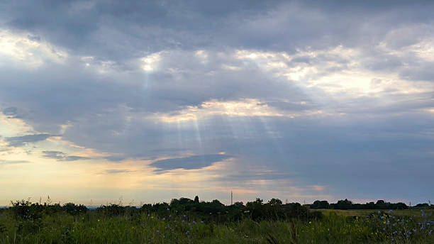 istock cloudy colorful clouds with sun rays over the rural landscape 2206777992