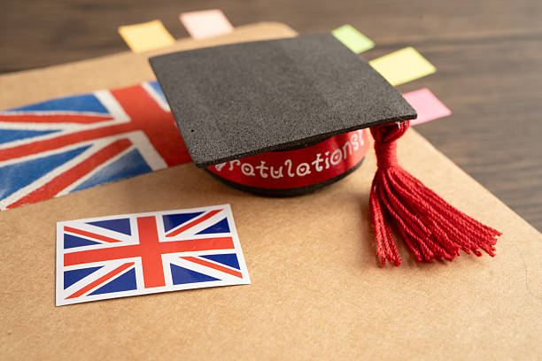 istock UK flag with graduate hat on english language book. 2206779071